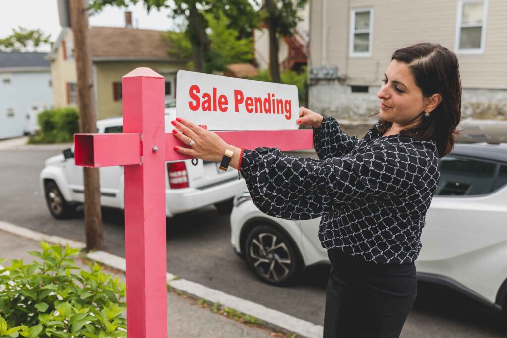 real estate agent with sale pending sign