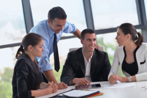 young people in professional attire smiling in meeting