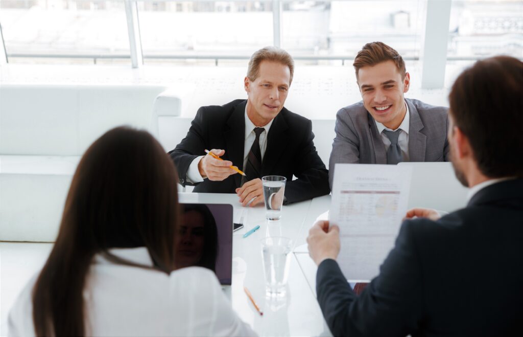 Business people sit by the table in conference room