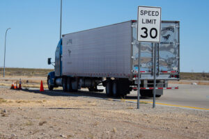 truck stopped on side of road with speed limit sign