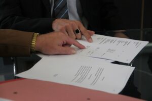 hands of two people pointing a provisions of a contract