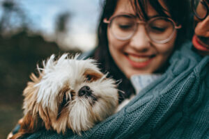 couple smiling and holding dog