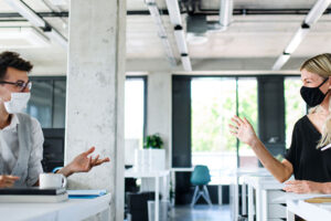 masked coworkers socially distancing