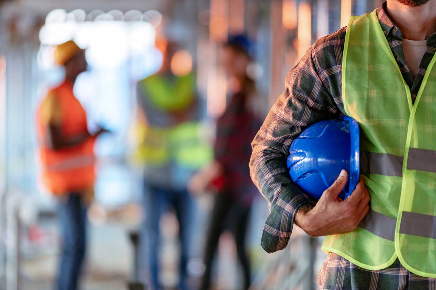Close up of a construction worker's hand holding working helmet.